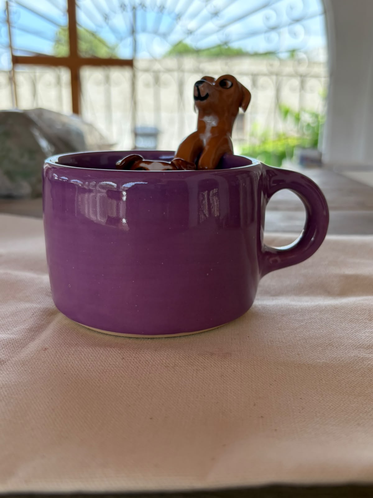 Taza violeta con perrito esculpido en el borde exterior listo para el café de la mañana ☕💜