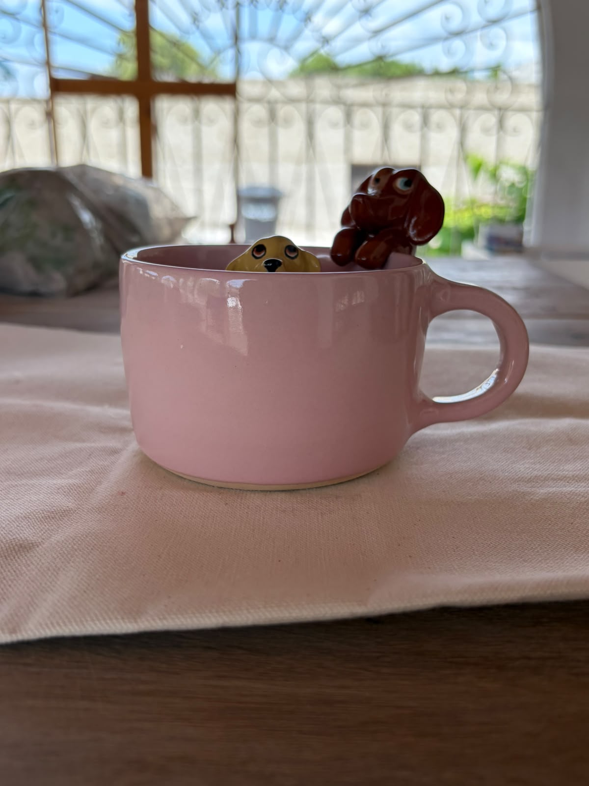 Taza artesanal con doble escultura sobre la mesa. ¡Agenda abierta para Diciembre! 🎄☕🐾